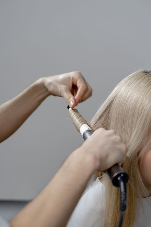 Professional styling long hair with a heated salon tool Professional styling long hair with a heated salon tool